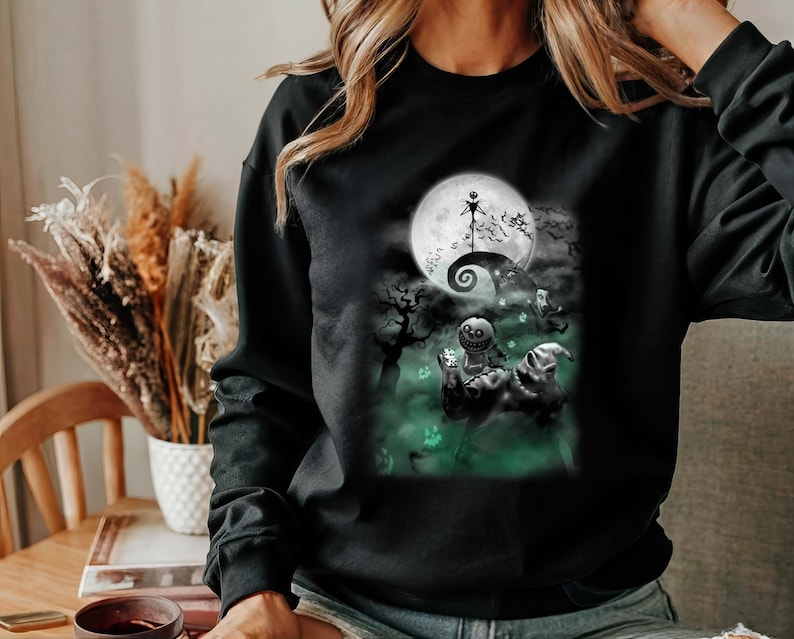 K&ouml;nnte beinhalten: Schwarzes Sweatshirt mit einem gr&uuml;n-wei&szlig;en Grafikdruck eines Charakters aus dem Film "Nightmare Before Christmas".