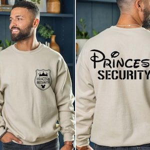 Princess Security Shirt – a funny and stylish Dad sweatshirt, perfect for Disney dads! Whether you're keeping the little ones safe at Disneyland or looking for a unique gift, this shirt is great for Father’s Day, birthdays, or as a gift for your boyfriend. Ideal for a Disneyland family trip, this shirt adds a fun touch to your Disney adventures while showing off your dad pride. Comfy, humorous, and perfect for making memories with your family!