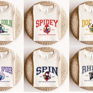 Spidey and His Amazing Friends T-shirt featuring Ghost Spider, Spiderman, and Marvel Avengers-inspired graphics. Perfect for superhero fans, birthday parties, or family matching outfits. This soft, high-quality tee is great for kids and adults who love action-packed fun. Ideal for Marvel lovers, Avengers-themed trips, or everyday superhero style with bold, colorful characters.
