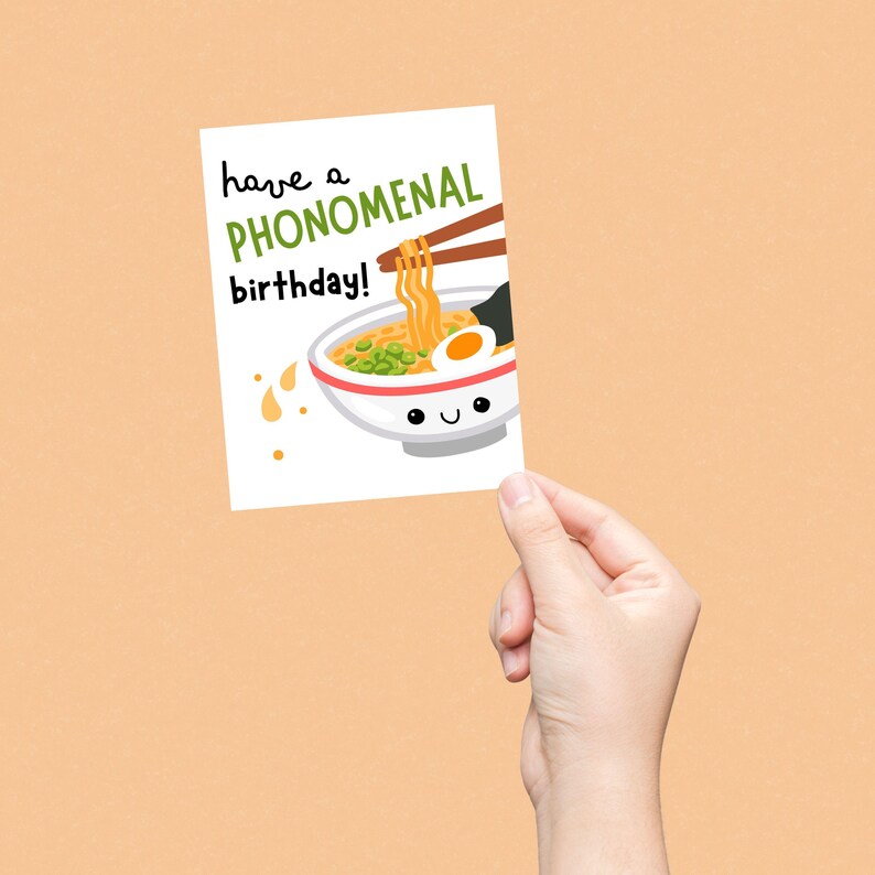 Funny birthday card with a cute smiling pho noodle bowl and the phrase "Have A Phonomenal Birthday", perfect for foodies, pho lovers, and pun lovers, ideal for sending fun and unique birthday wishes.