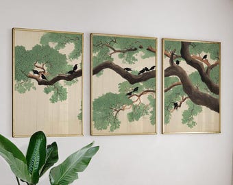 May include: A triptych of framed art prints depicting a tree with green leaves and dark branches. Black birds are perched on the branches. The artwork has a gold frame and a neutral background.