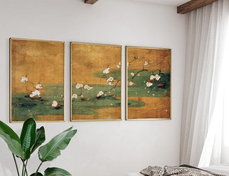May include: Three framed wall art pieces with a vintage aesthetic. Each features a gold frame and a painting of white flowers on branches over a green and gold background. The artwork evokes a sense of traditional Asian art.