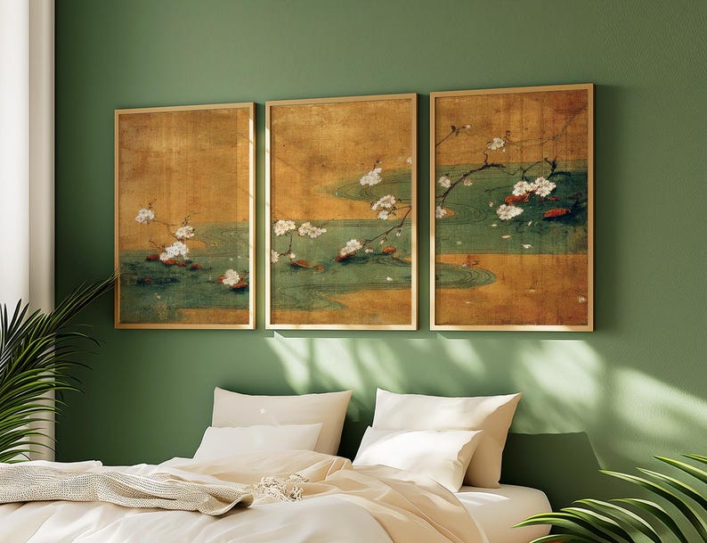 May include: Three framed art prints depicting a serene pond scene with white blossoms and red accents. The artwork features a gold background and a green pond with lily pads. The frames are gold, and the overall aesthetic is calming and nature-inspired.