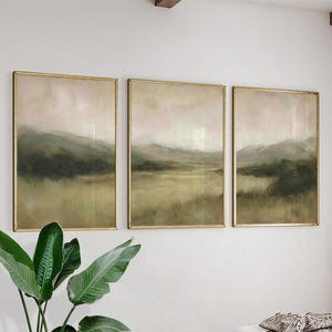Peut inclure: Ensemble de trois impressions d'art encadrées représentant un paysage. Chaque œuvre présente une palette de couleurs douces de vert, beige et rose, avec des montagnes. Les cadres dorés ajoutent une touche d'élégance à l'ensemble.