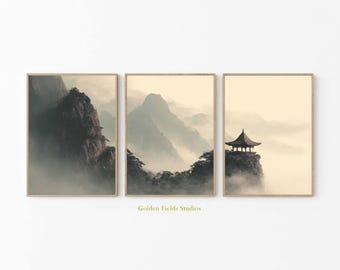 May include: Set of three framed landscape prints. The prints depict misty mountain scenes, including a pagoda on a cliff. The color palette is muted, with tones of beige, gray, and brown. The text "Golden Fields Studios" is visible.