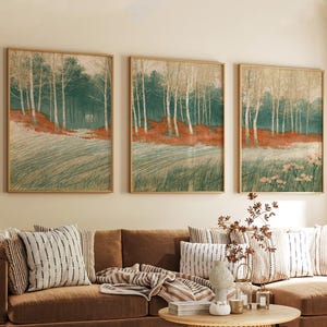 Könnte beinhalten: Ein Set aus drei gerahmten Wandbildern, die eine Waldlandschaft mit hohen weißen Bäumen, dunkelgrünem Laub und einem Vordergrund aus strukturiertem grünem Gras sowie rotbraunem Bodenbewuchs zeigen, in dünnen hellen Holzrahmen.