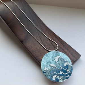 Blue round Japanese style wave scene pendent  on a Silver plated 18 inch snake chain.