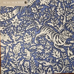May include: A blue and white fabric with a repeating pattern of tigers, birds, and floral designs. The fabric is from Schumacher, a company that has been in business since 1889.