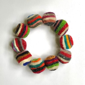 May include: A circle of colorful felt balls, each with stripes of different colors, including red, blue, green, yellow, and brown.
