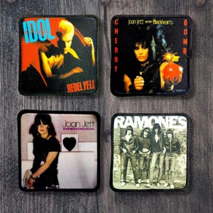 以下が含まれることがあります： 象徴的なロックアルバムのアートワークが特徴の4つの正方形パッチ。 「IDOL REBEL YELL」というテキストのパッチ、ジョーン・ジェットのパッチ、そして「Joan Jett」と「RAMONES」というテキストの2つのパッチが含まれています。