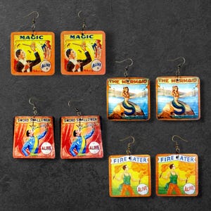 May include: A white ceramic mug with a black handle and the text "But First, Coffee" in a black, handwritten-style font. The mug is on a white surface.