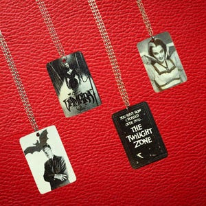 Op de afbeelding: Een set van drie keramische mokken met een gespikkelde, matte afwerking. De mokken zijn in crème, lichtgrijs en donkergrijs. Elke mok heeft een eenvoudig, minimalistisch ontwerp.