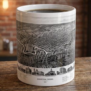 May include: A white ceramic mug featuring a black and white aerial map illustration of Houston, Texas, from 1891. The design includes a detailed bird's-eye view of the city grid, a river, and a row of historic building sketches with the text Houston, Texas 1891.