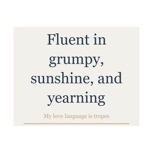 May include: A square graphic print on a light cream background featuring dark blue text that reads Fluent in grumpy, sunshine, and yearning. Below this, smaller light orange text reads My love language is tropes, underlined by a thin orange line.