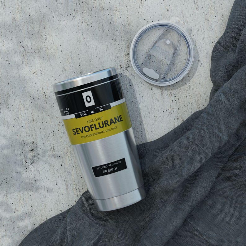 Puede incluir: Un vaso de acero inoxidable con tapa transparente extra&iacute;ble. El vaso presenta una etiqueta amarilla con texto negro que dice SEVOFLURANE, USE ONLY, FOR PROFESSIONAL USE ONLY, y una etiqueta negra con texto blanco IF FOUND, RETURN TO DR SMITH.