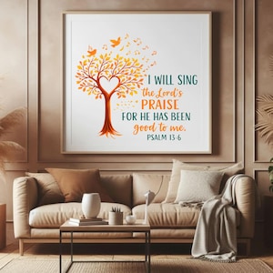 Può includere: Opera d'arte da parete incorniciata con un albero con centro a forma di cuore, foglie arancioni e note musicali. Il testo recita: "I WILL SING the Lord's PRAISE FOR HE HAS BEEN good to me. PSALM 13:6". L'opera è sopra un divano beige.