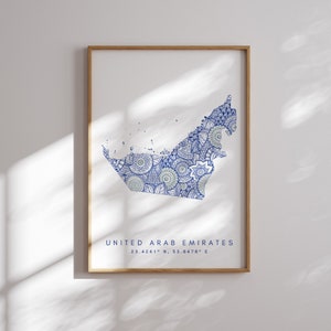 Könnte beinhalten: Ein gerahmter Druck einer Karte der Vereinigten Arabischen Emirate. Die Karte ist mit komplizierten blauen und grünen Mandala-Mustern gefüllt. Der Text "UNITED ARAB EMIRATES" und "23.4241° N, 53.8478° E" ist unter der Karte gedruckt.
