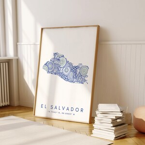 Peut inclure: Une illustration de style mandala bleue et verte de la silhouette d'El Salvador. Le texte "EL SALVADOR" et les coordonn&eacute;es "13.7942&deg; N, 88.8965&deg; W" sont imprim&eacute;s sous la carte.