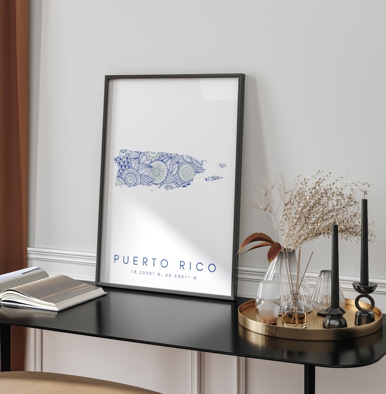 May include: A black framed print featuring a blue and white stylised map of Puerto Rico. The text "PUERTO RICO 18.2208&deg; N, 66.5901&deg; W" is below the map.