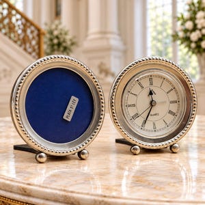 Puede incluir: Un marco circular de plata con borde de cuentas y fondo de terciopelo azul que incluye una etiqueta plateada con la inscripción PLATA 1ª LEY, junto a un reloj de cuarzo circular a juego con esfera blanca y números romanos negros.