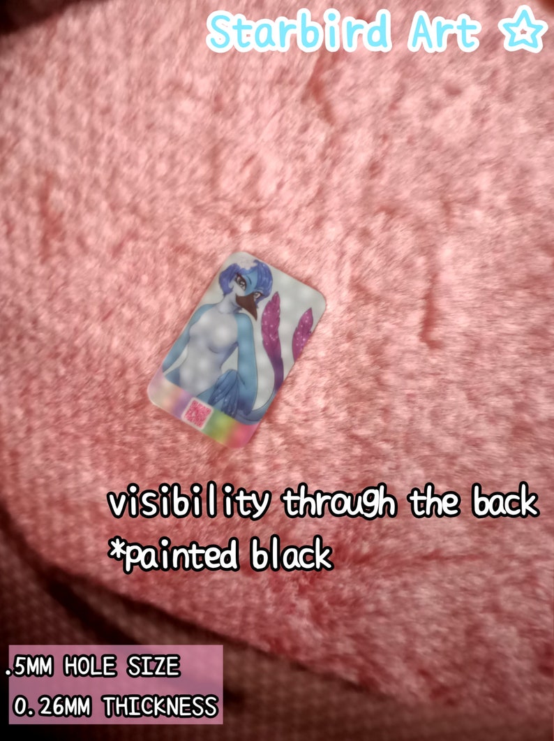 May include: A rectangular, transparent acrylic charm featuring a blue and purple mermaid illustration. The charm has a .5mm hole and is 0.26mm thick. Text on the charm reads "visibility through the back *painted black". The background is pink.