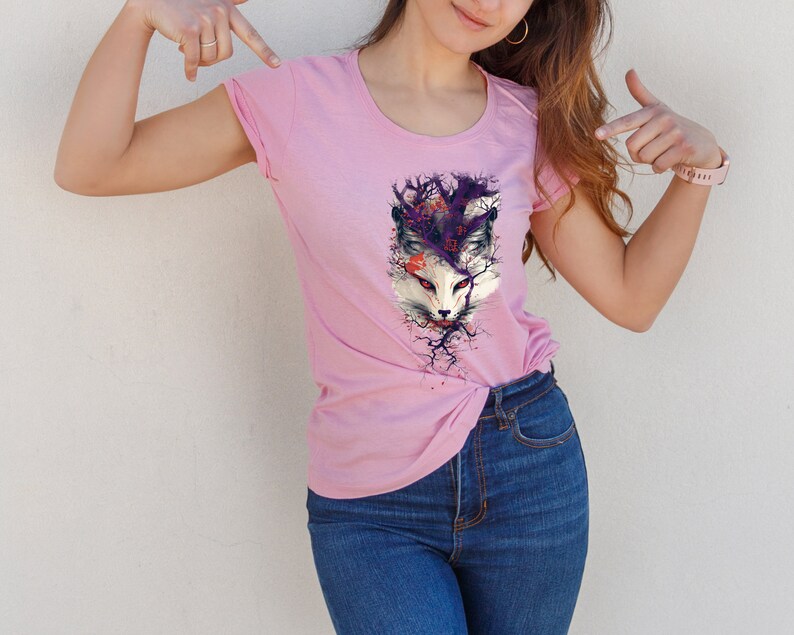 May include: A pink t-shirt with a graphic print of a white fox's face surrounded by purple and black branches.