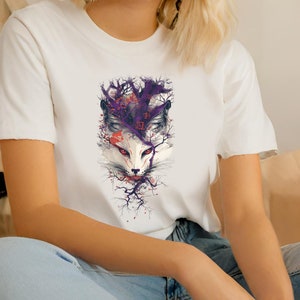 May include: White t-shirt with a graphic print of a white fox with purple and red accents. The fox is surrounded by branches and flowers.