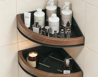 May include: Two stacked corner shelves featuring a matte black metal base and a curved wood-grain front trim. The shelves are mounted in a tiled corner and hold various skincare bottles, including SK-II and Botanist brands, and a glass candle.