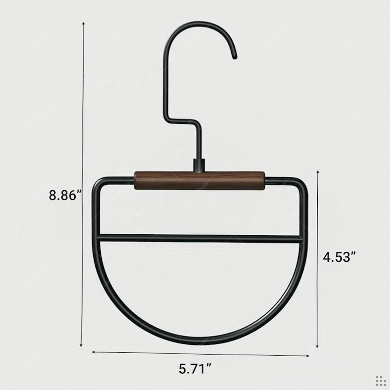 May include: A black metal hanger with a dark wood accent. The hanger is 8.86 inches tall, 5.71 inches wide, and the bottom section is 4.53 inches tall. The design is modern and minimalist, suitable for clothing storage.