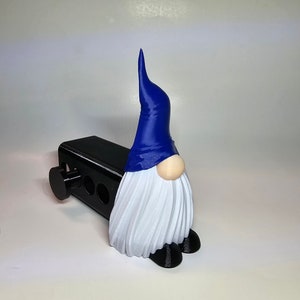 Puede incluir: Un divertido protector de enganche de remolque con forma de gnomo. El gnomo tiene un gorro azul, barba blanca y nariz beige. El protector es negro y tiene un botón redondo. Accesorio decorativo para vehículos.