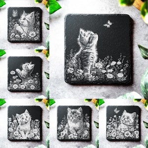 以下が含まれることがあります： 花畑の中で子猫の白いシルエットが描かれた、黒いスレート製のコースター6枚セット。コースターごとに子猫のポーズと蝶が異なります。