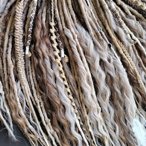 May include: A set of brown, blonde, and white synthetic dreadlocks with beads and charms. The dreadlocks are wavy and have a natural look.