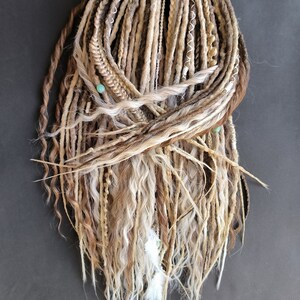 May include: A set of long, brown, blonde, and white synthetic dreadlocks with beads and feathers.