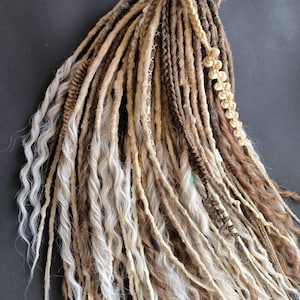 May include: A set of synthetic dreadlocks in shades of brown, beige, and white. The dreadlocks are long and wavy, with some braided sections.