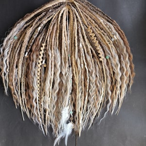 May include: A set of long, wavy synthetic dreadlocks in shades of brown, blonde, and white. The dreadlocks are decorated with beads, feathers, and other embellishments.