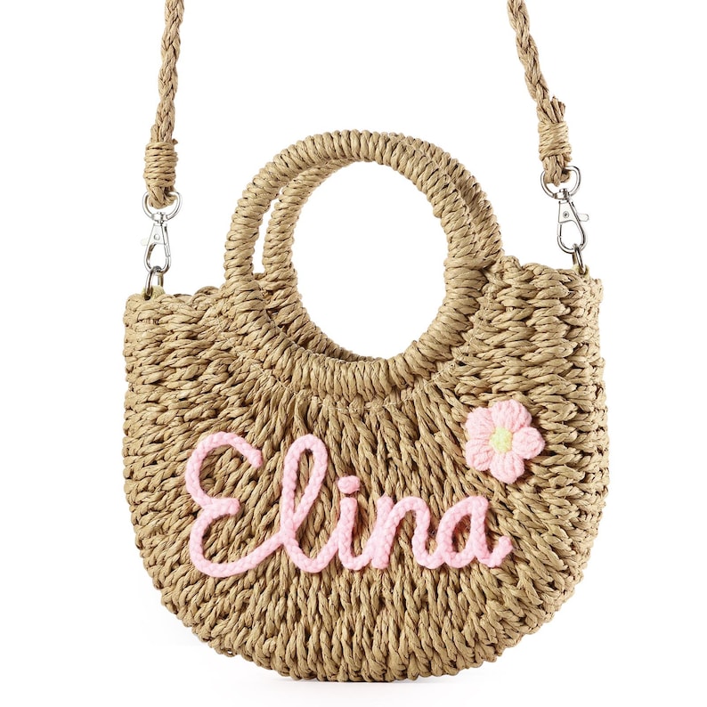 May include: A straw tote bag with a pink flower and the name "Elina" embroidered on the front.