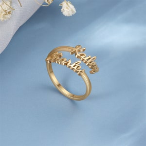 Op de afbeelding: Gouden ring met de namen "Katelyn" en "Charles" die in elkaar zijn gevlochten.