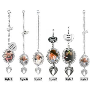May include: Six silver-toned metal hanging ornaments featuring oval photo frames, chains, and angel wing charms. Styles include graduation caps, the year 2026, and heart-shaped charms with text such as Congratulations on your graduation and Du bist immer in meinem Herzen.