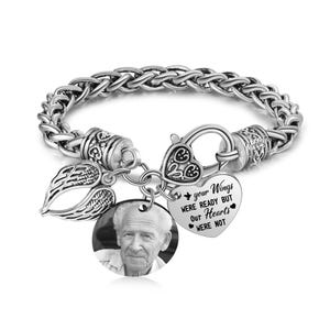 Puede incluir: Pulsera de plata con un dije en forma de coraz&oacute;n que dice "Tus alas estaban listas pero nuestros corazones no lo estaban". La pulsera tambi&eacute;n tiene un peque&ntilde;o dije de ala de &aacute;ngel y un dije de foto.