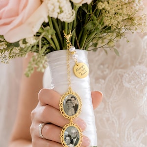 Pu&ograve; includere: Un ciondolo per bouquet da sposa in metallo dorato con due cornici ovali contenenti ritratti in bianco e nero, un piccolo ciondolo rotondo inciso con il testo Always in our heart e due perle artificiali bianche su una catenina dorata.