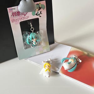 Può includere: Una collezione di portachiavi in stile anime con personaggi di Hatsune Miku. Un portachiavi è ancora nella sua confezione originale, mentre gli altri sono esposti separatamente. I portachiavi hanno colori vivaci e design dettagliati.