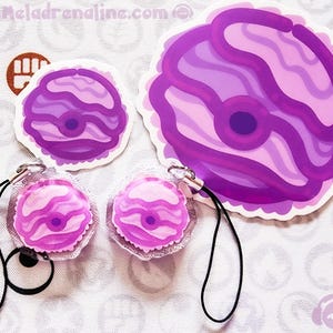 May include: A set of three ceramic mugs with a speckled, matte finish. The mugs are in shades of cream, light brown, and dark brown. Each mug has a simple, minimalist design and a rounded handle.