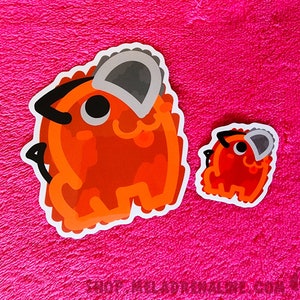 May include: Two orange cartoon animal stickers with black eyes and gray ears. The larger sticker is about 2 inches tall and the smaller sticker is about 1 inch tall.