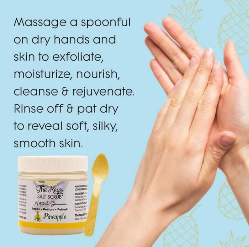 Puede incluir: Un frasco de "The Keys Salt Scrub" con texto "Pineapple", una cuchara de madera y manos. El texto en el frasco dice "Masajear una cucharada sobre las manos y la piel secas para exfoliar, hidratar, nutrir, limpiar y rejuvenecer."