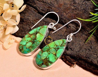 May include: A pair of silver dangle earrings with green turquoise stones. The stones are a mottled green colour with brown accents.