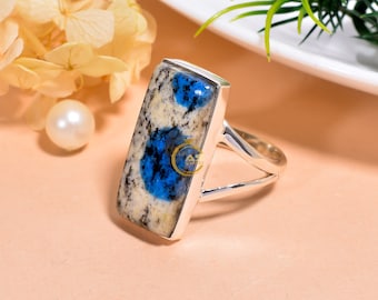 May include: A silver ring with a rectangular blue and white stone. The stone has a swirling pattern of blue and white.