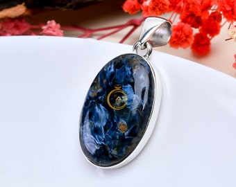 May include: A silver pendant with a blue and gold tiger's eye stone. The stone is oval shaped and has a unique pattern.