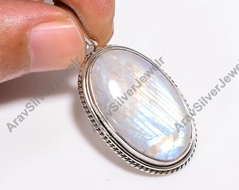 May include: A silver pendant with a large oval moonstone. The moonstone has a white iridescent sheen and is set in a silver bezel with a rope-like border.