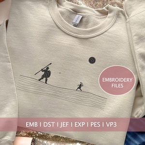 Peut inclure: Sweat-shirt beige avec un motif brodé noir représentant une personne avec une lance et un bouclier marchant sur un chemin avec une personne plus petite courant derrière elle. Le texte "EMBROIDERY FILES" est dans un cercle rose sur le côté droit de l'image. Le texte "EMB | DST | JEF | EXP | PES | VP3" est en bas de l'image.
