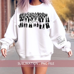 May include: White sweatshirt with a black silhouette of a crowd of people and the text "By His Wounds We Are Healed Isaiah 53:5".